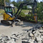 Excavator breaking up concrete